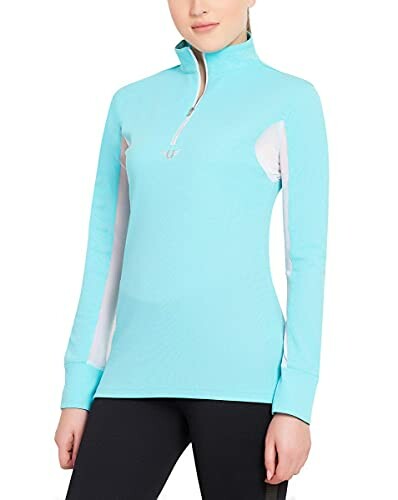 Woman wearing a blue long-sleeve activewear top with zipper.