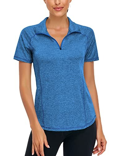 Woman wearing a blue short-sleeve activewear top with a zipper.