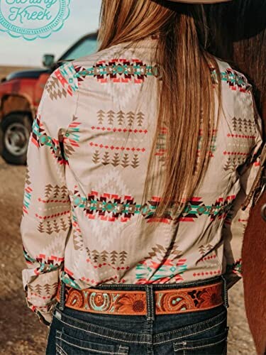 Person wearing a colorful western-style shirt and belt.