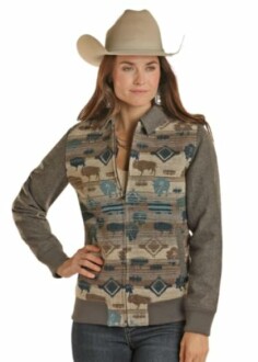 Woman wearing a patterned western jacket and cowboy hat.