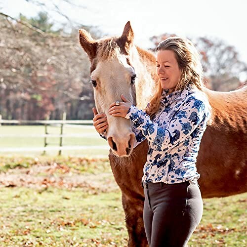 Woman interacting with a horse in an outdoor setting.